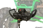 Hand positioning the winch receiver mount with a winch fitted on a UTV with a green frame