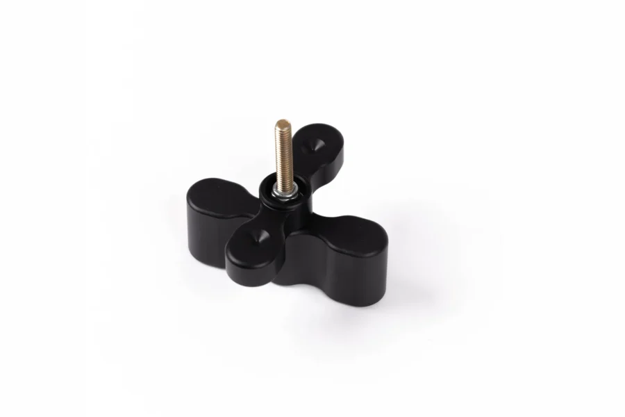 Black anodized pack mount extension with a brass threaded stud, angled on a white background