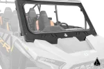 Black framed glass windshield with vented lower trim mounted on a Polaris RZR XP, front three quarter view