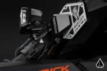 Side mirror light bracket holding a cube LED light next to a UTV side mirror on a roll cage tube