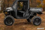 Can-Am Defender with soft cab enclosure doors installed, side profile parked on grass in front of autumn woods