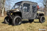 Camo Can-Am Defender MAX with black soft enclosure doors on all four openings, side profile in a winter field