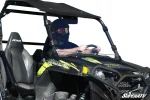 Rider at the wheel of a black Polaris RZR 900 with the clear windshield clamped to the cage