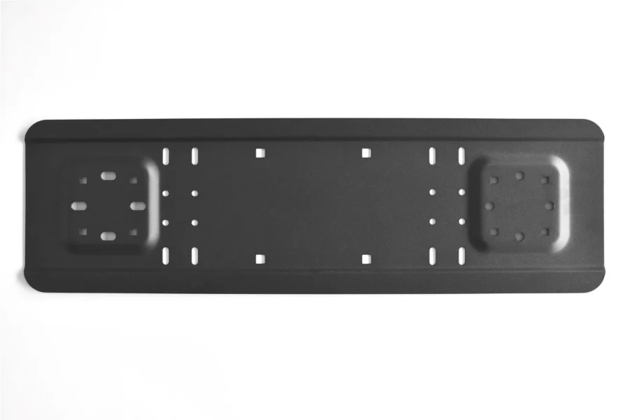 Long black powder-coated universal mounting plate with two recessed pack pads and rows of slotted bolt holes