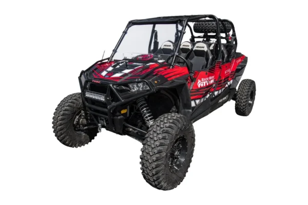 Clear Tusk vented polycarbonate windshield installed on a red and black Polaris RZR, front three-quarter view