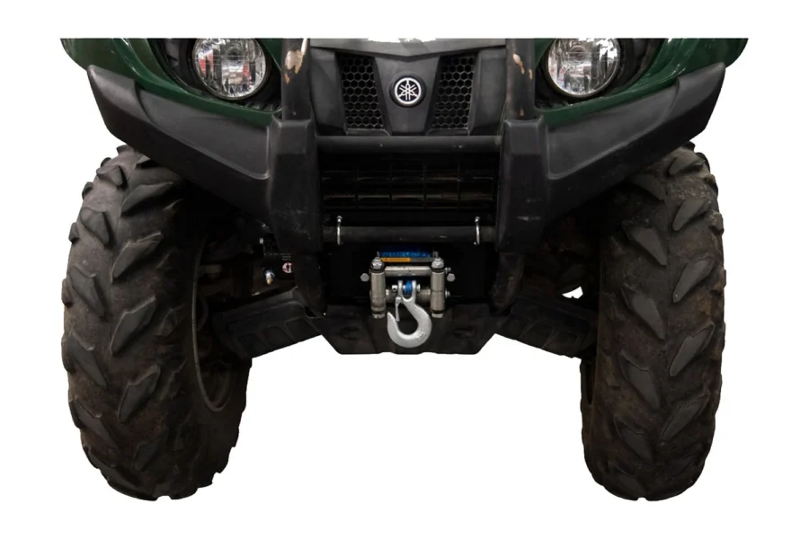 Winch and Tusk mount installed on the front of a green Yamaha Grizzly, hook and fairlead below the grille