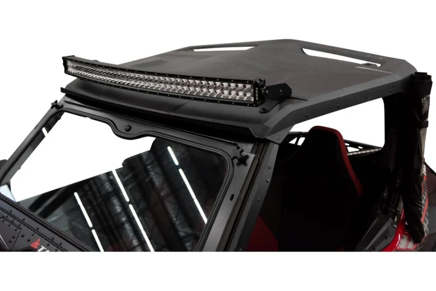 Curved Tusk LED light bar mounted across the front of a black UTV roof over the windshield
