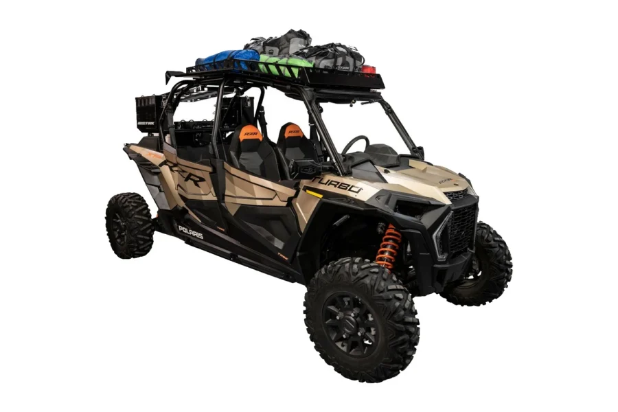 Tan Polaris RZR XP 4 turbo with the Tusk roof rack loaded with gear bags, front three-quarter view