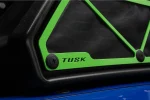 Close-up of a Tusk green intake cover corner with TUSK lettering over black prefilter mesh