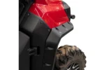 Tusk fender flare mounted on a red UTV fender above a muddy front tire, close view