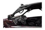 Cockpit of a Can-Am X3 showing a Tusk grab handle on the cage above the steering wheel and mirror
