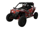 Tusk folding windshield installed on a red and gray Polaris RZR, front three-quarter view