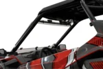 Close-up of the Tusk windshield folded open against the roof and cage of a red Polaris RZR