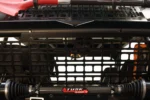 Front view of a Tusk MOLLE panel mounted behind UTV seats above the prop shaft and CV axles