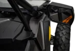 Glass side of a black Tusk folding mirror mounted to the cage bar of a UTV, close view