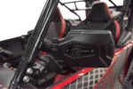 Tusk folding mirror installed on a red UTV roll cage, black housing with Tusk logo facing the seats