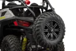 Close-up of a spare tire mounted on the Tusk carrier at the rear of a Polaris RZR