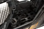 Tusk black seat cargo rack mounted behind the seat of a Can-Am UTV, angled view with drive belt