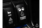 Mirror lights rocker switch next to a horn and hazard lights switch